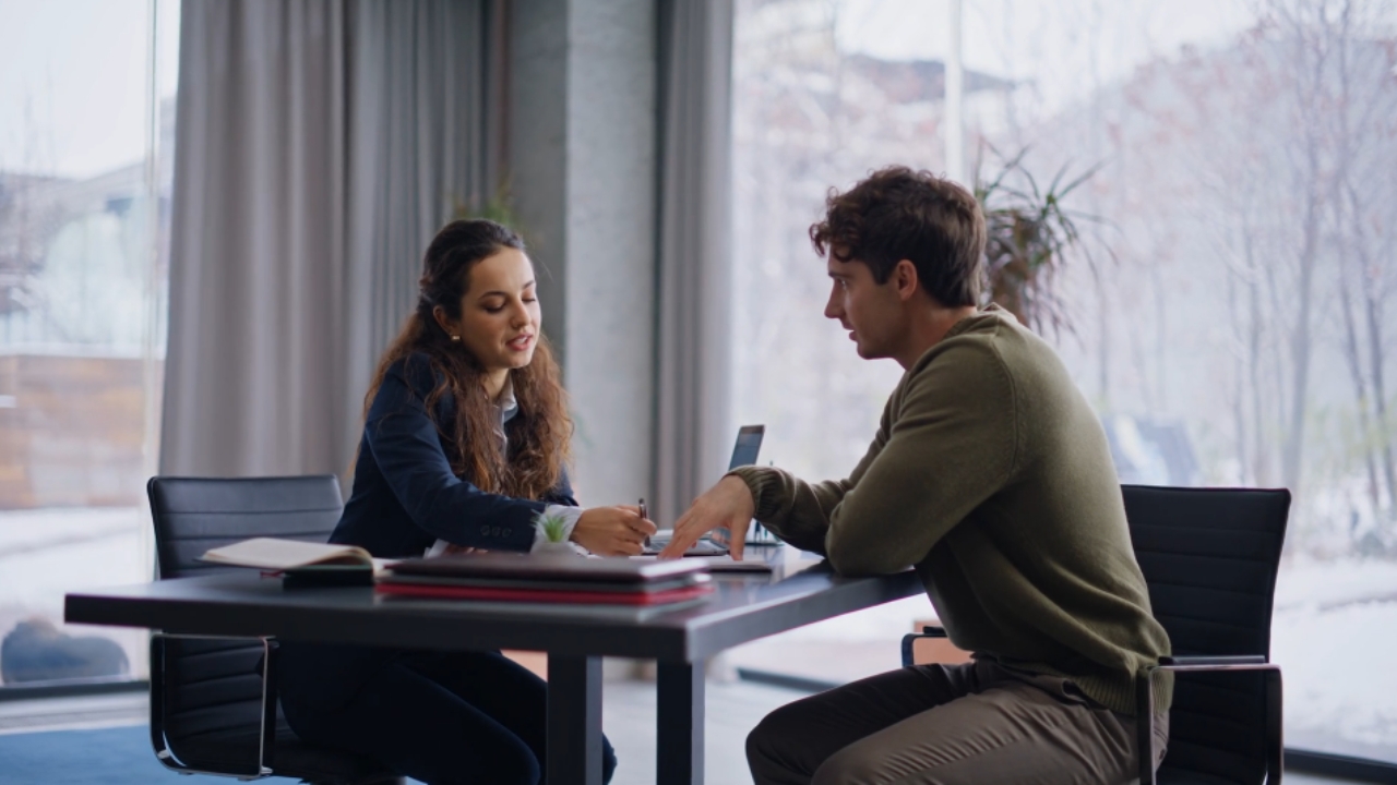 Travel advisor meets with a client at an office desk